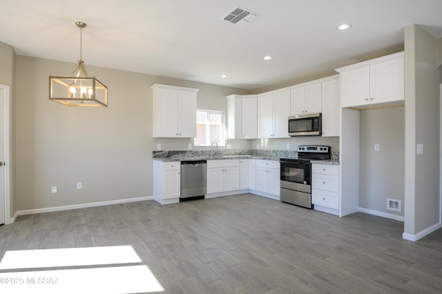 kitchen featuring visible vents, appliances with stainless steel finishes, light wood-type flooring, white cabinetry, and a sink