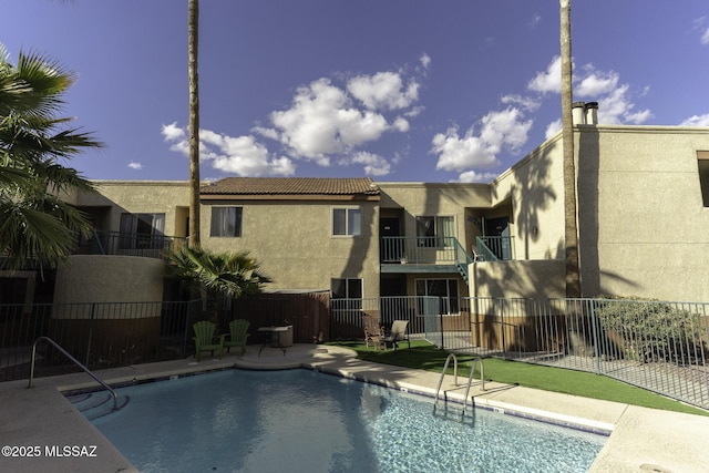 community pool featuring a patio area and fence