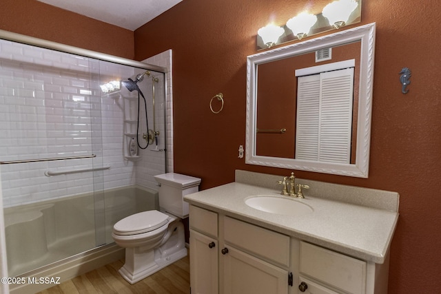 full bathroom with wood finished floors, toilet, a stall shower, and vanity