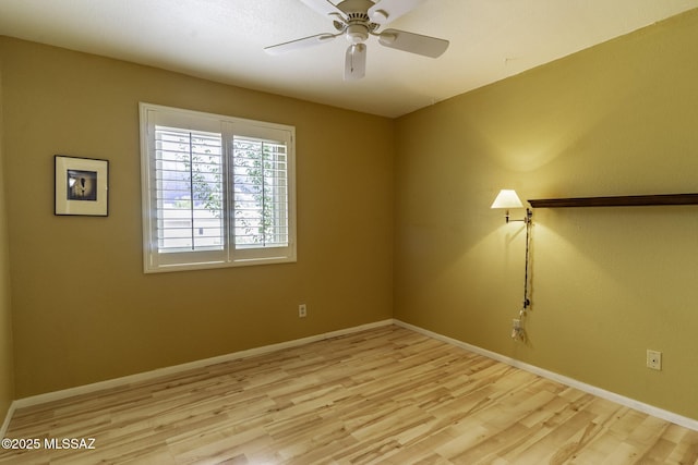 empty room featuring baseboards and light wood finished floors