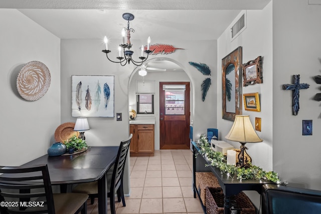 dining space with visible vents, arched walkways, light tile patterned flooring, and a chandelier