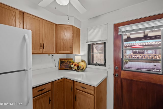 kitchen featuring light countertops, freestanding refrigerator, and ceiling fan