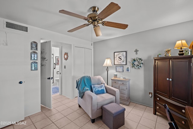 sitting room featuring light tile patterned flooring, visible vents, and ceiling fan