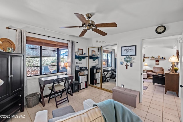 office featuring light tile patterned floors, a healthy amount of sunlight, and a ceiling fan