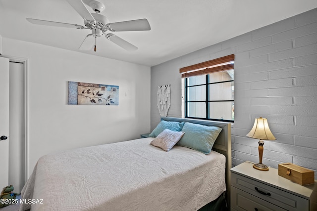 bedroom with brick wall and a ceiling fan