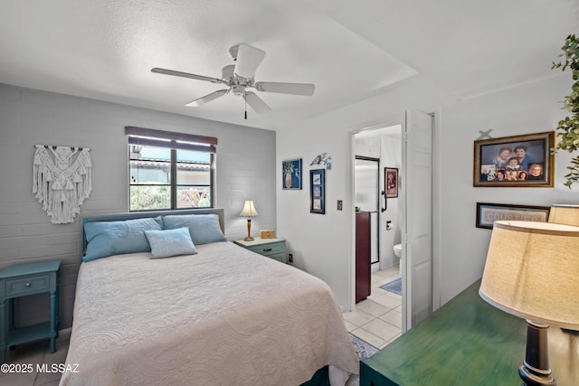 bedroom with light tile patterned floors, connected bathroom, a textured ceiling, and a ceiling fan