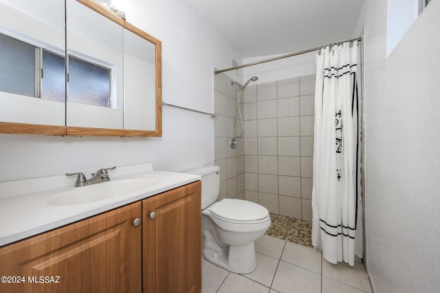 full bathroom featuring tiled shower, vanity, toilet, and tile patterned floors