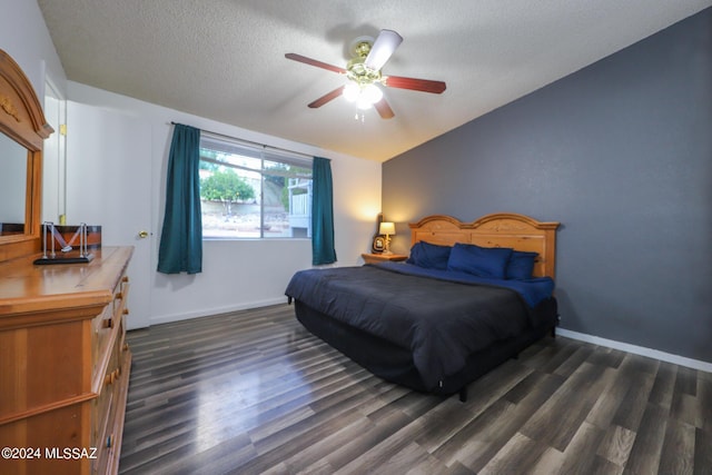 bedroom with baseboards, ceiling fan, dark wood-type flooring, vaulted ceiling, and a textured ceiling