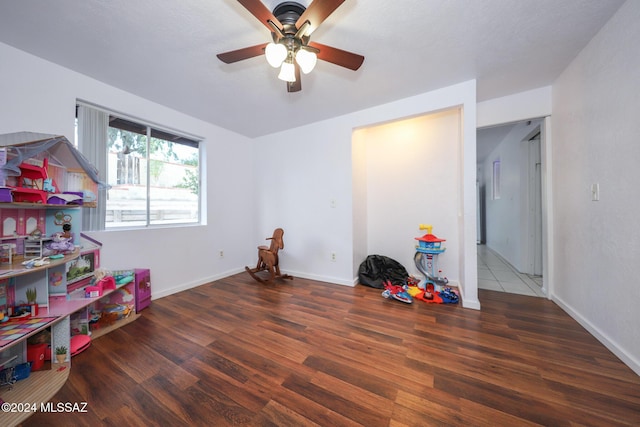 playroom featuring ceiling fan, baseboards, and wood finished floors