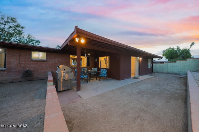 exterior space featuring a patio area, fence, and brick siding