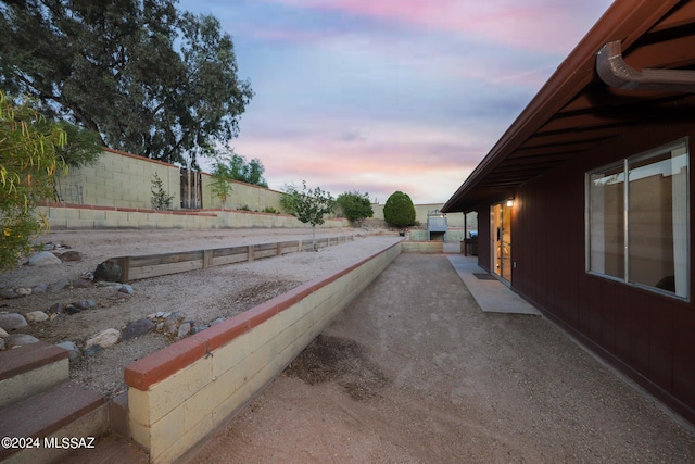 yard at dusk featuring fence