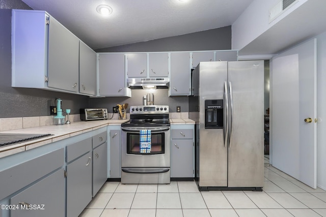 kitchen with appliances with stainless steel finishes, lofted ceiling, under cabinet range hood, and gray cabinetry