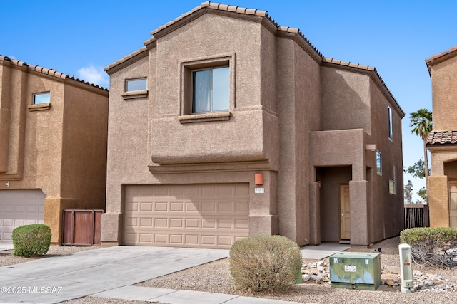 view of front of property with concrete driveway, an attached garage, a tiled roof, and stucco siding