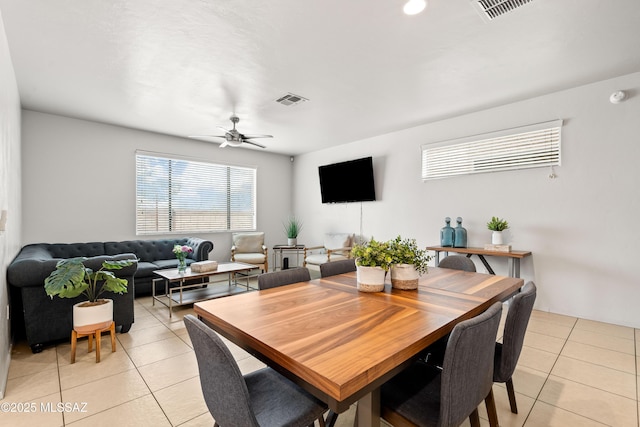 dining area with light tile patterned floors, visible vents, and a ceiling fan