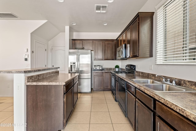 kitchen featuring light tile patterned floors, a sink, visible vents, a center island, and black appliances