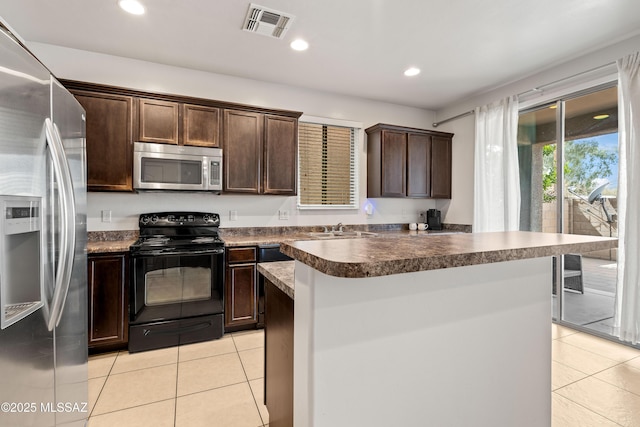 kitchen featuring dark brown cabinetry, visible vents, stainless steel appliances, a sink, and light tile patterned flooring