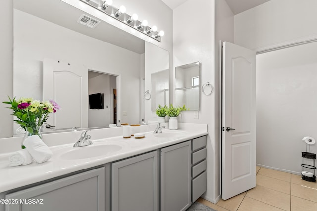 bathroom featuring double vanity, visible vents, a sink, and tile patterned floors