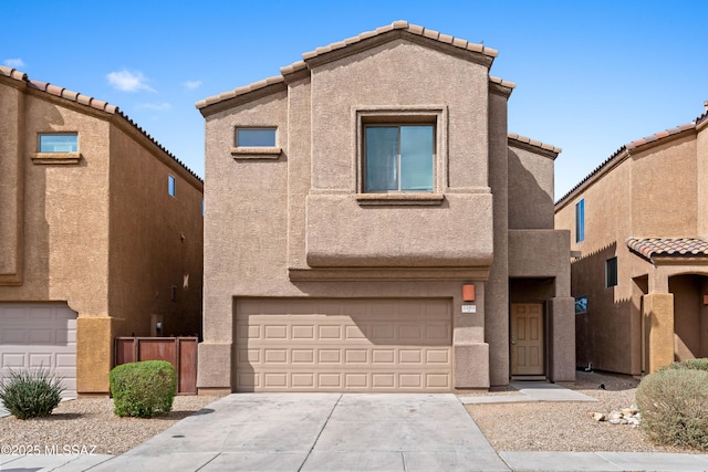 view of front of house with a garage, concrete driveway, a tile roof, and stucco siding