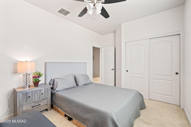 bedroom featuring a closet, light colored carpet, visible vents, a ceiling fan, and baseboards