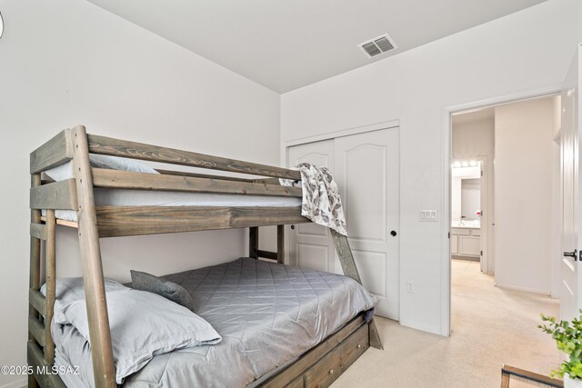 bedroom featuring a closet, visible vents, and light colored carpet