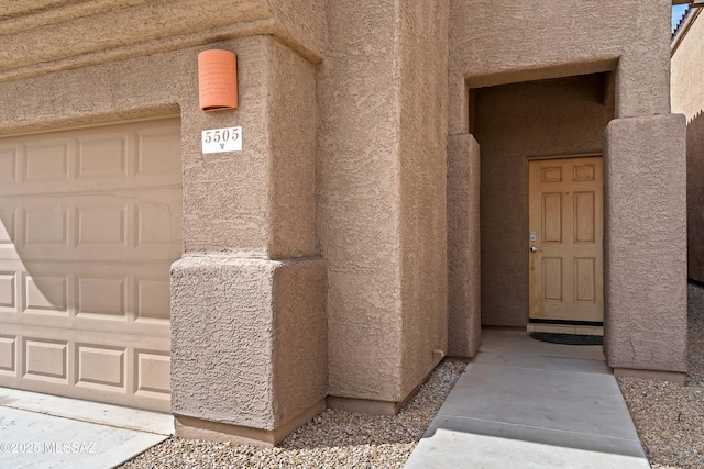 entrance to property featuring stucco siding