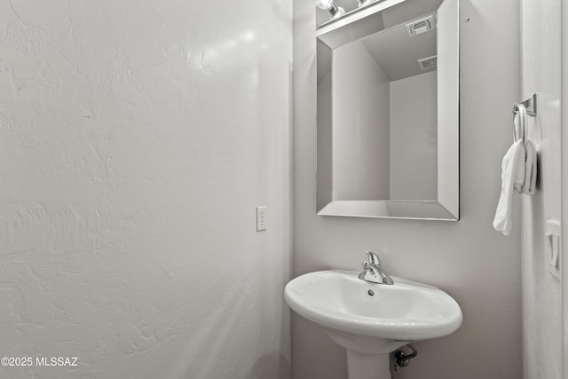 bathroom featuring visible vents and a sink