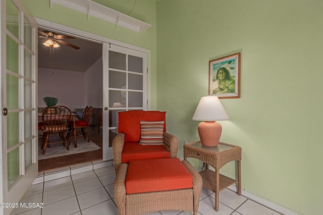 sitting room featuring french doors, a ceiling fan, and tile patterned floors