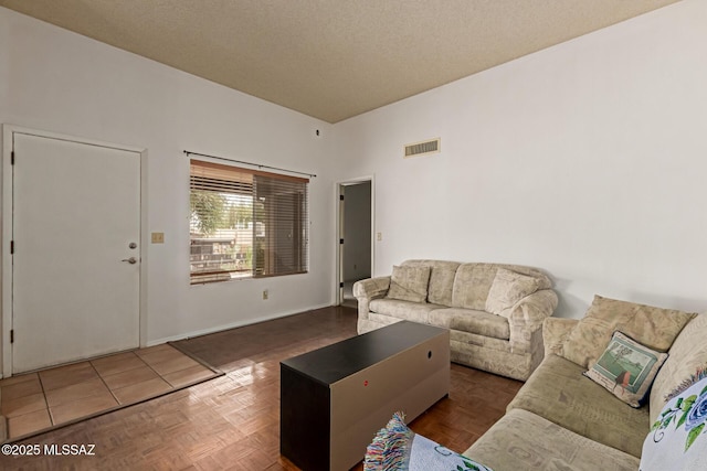 living area featuring visible vents and a textured ceiling