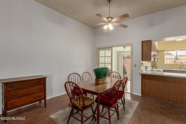 dining area featuring ceiling fan, a textured ceiling, and baseboards