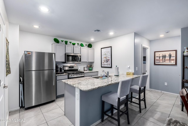 kitchen with a sink, stainless steel appliances, visible vents, and gray cabinets