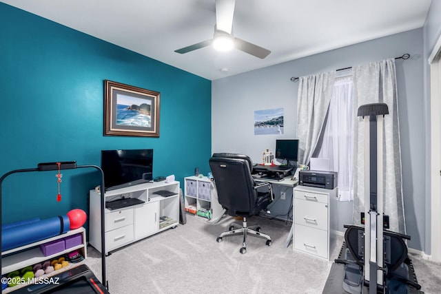 carpeted office space featuring ceiling fan