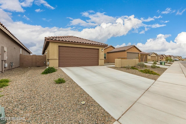 mediterranean / spanish home with stucco siding, fence, concrete driveway, and a tiled roof