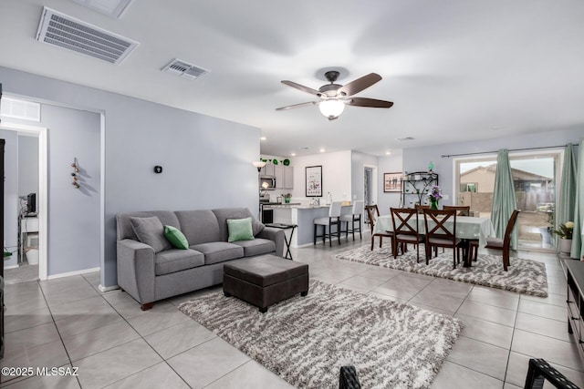 living room featuring ceiling fan, visible vents, light tile patterned flooring, and recessed lighting