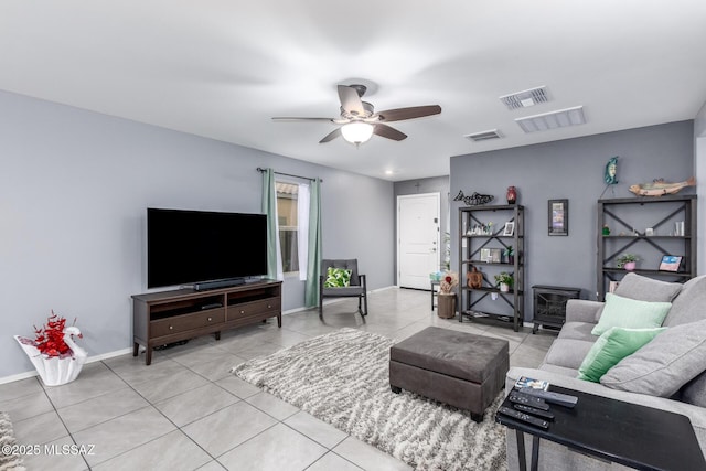 living area featuring light tile patterned floors, a ceiling fan, visible vents, and baseboards