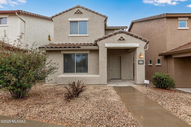 view of front of house featuring a tiled roof and stucco siding