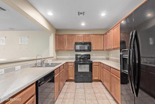 kitchen with light tile patterned floors, recessed lighting, a sink, light countertops, and black appliances