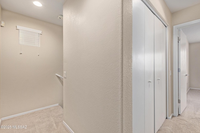 hall with recessed lighting, light colored carpet, and baseboards