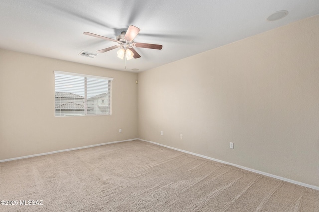 carpeted empty room featuring ceiling fan, visible vents, and baseboards