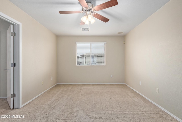 carpeted empty room featuring ceiling fan, visible vents, and baseboards