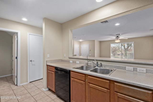 kitchen with light tile patterned floors, a sink, visible vents, black dishwasher, and light countertops