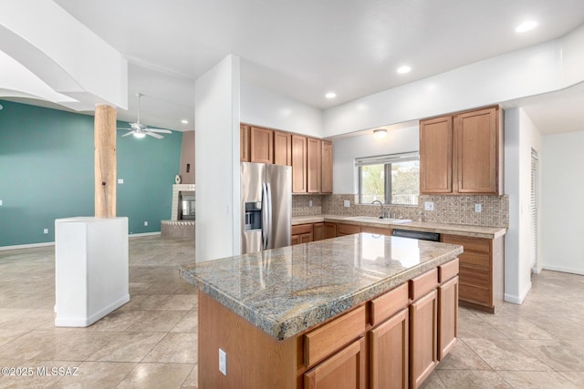 kitchen with tasteful backsplash, a fireplace, a sink, and stainless steel fridge with ice dispenser