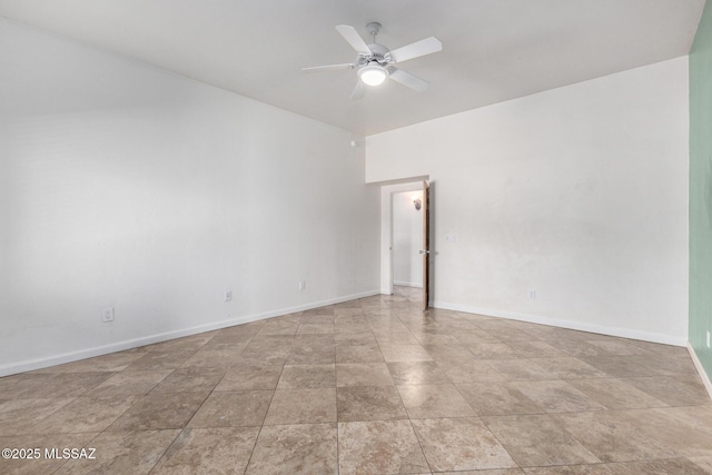 empty room with ceiling fan and baseboards