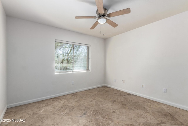 unfurnished room featuring ceiling fan and baseboards