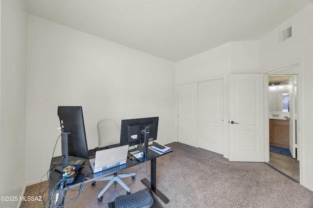 carpeted office featuring visible vents and a sink