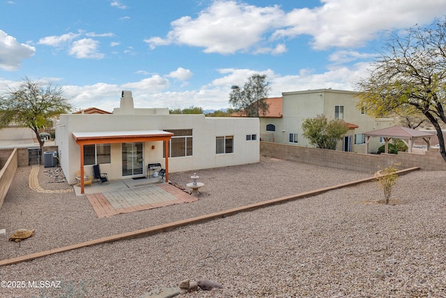 back of house featuring a patio area, central AC unit, a fenced backyard, and stucco siding