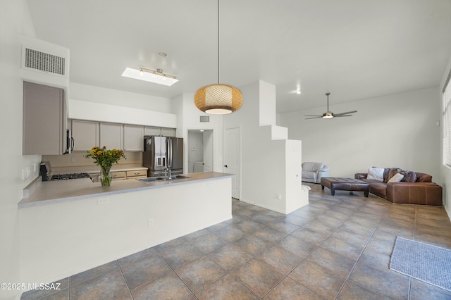 kitchen with visible vents, gray cabinetry, stainless steel appliances, a peninsula, and light countertops