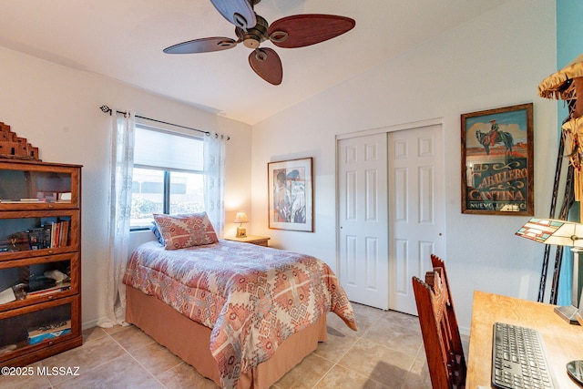 bedroom with lofted ceiling, a closet, ceiling fan, and light tile patterned floors