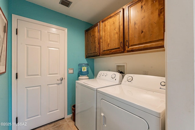 laundry room with cabinet space, washing machine and dryer, and visible vents