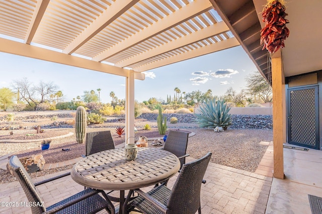 view of patio featuring outdoor dining area, fence, and a pergola