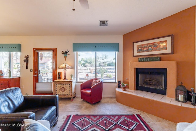 living area featuring tile patterned flooring, a fireplace, and visible vents